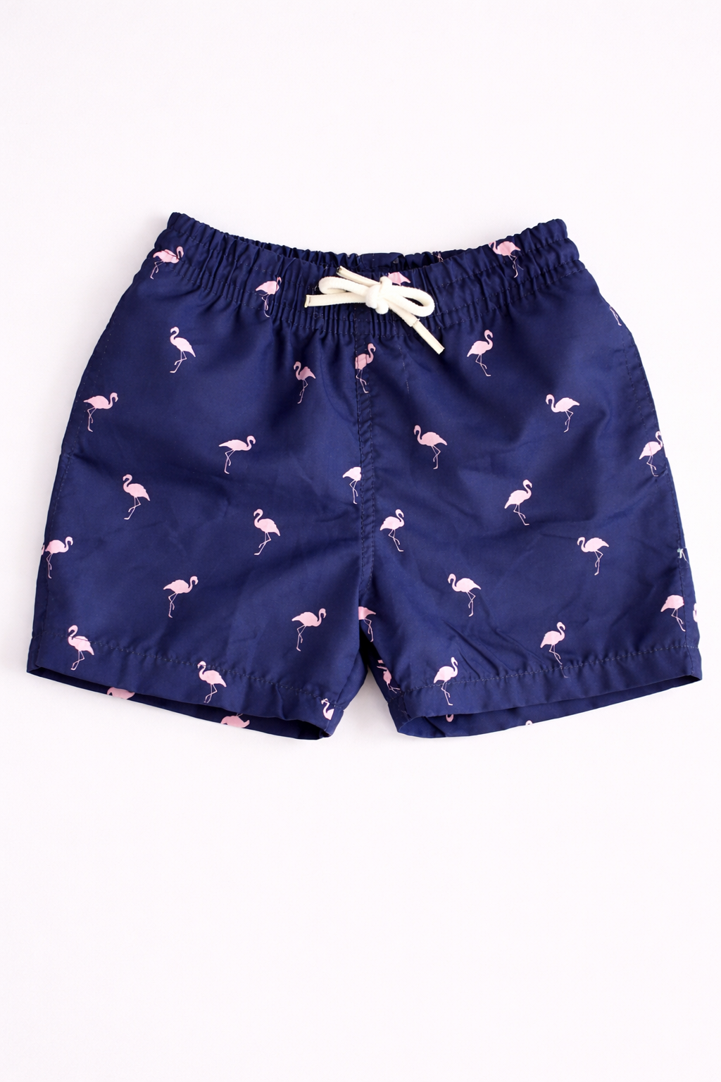 Navy blue shorts with flamingo pattern on a white background